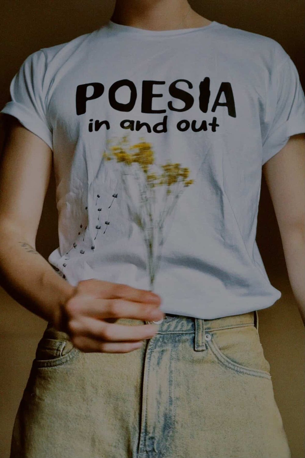 Persona vistiendo la camiseta Poesía In And Out con flores secas